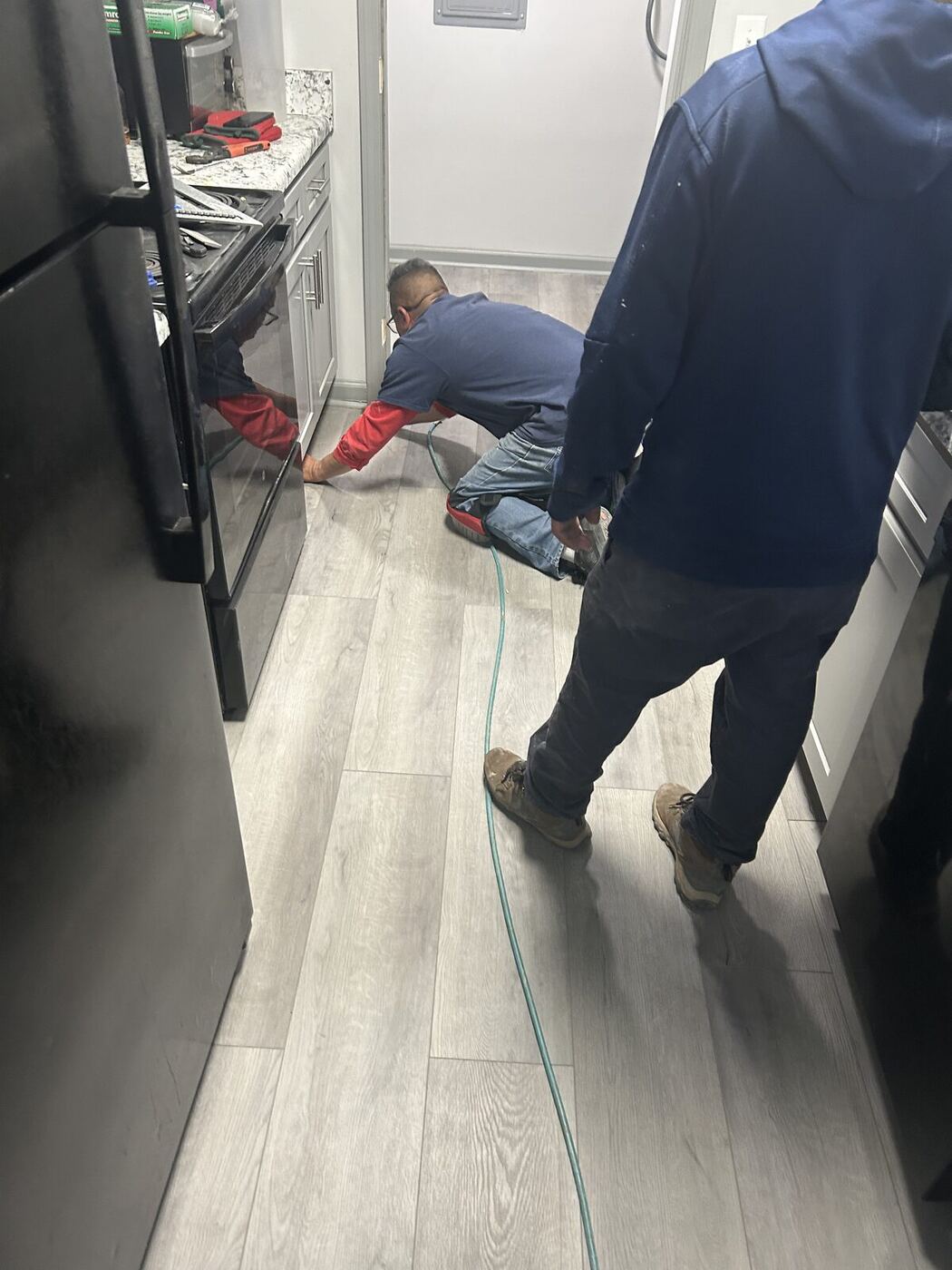 Installer fitting replacement flooring during a restoration rebuild