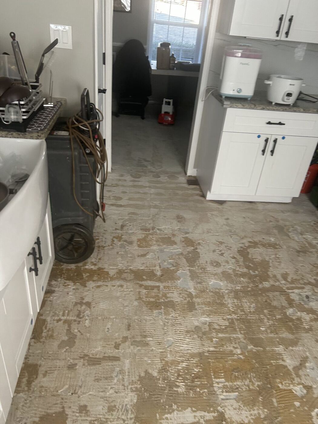 Air mover drying a kitchen floor after a water leak
