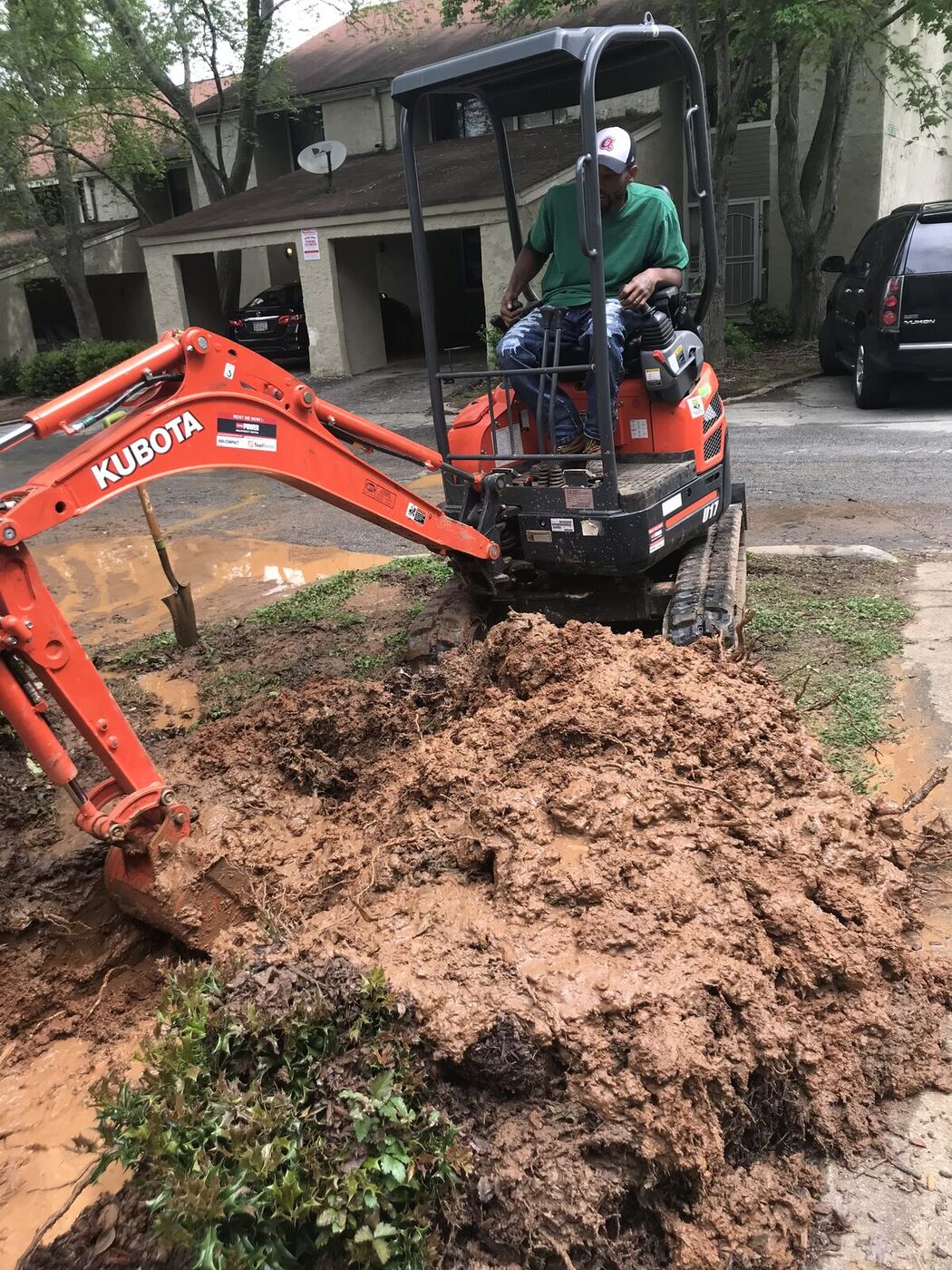 Morris Plumbing operator running a compact excavator on a sewer replacement