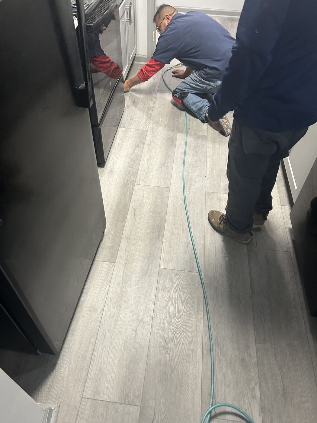 Restoration crew laying new plank flooring after a water loss