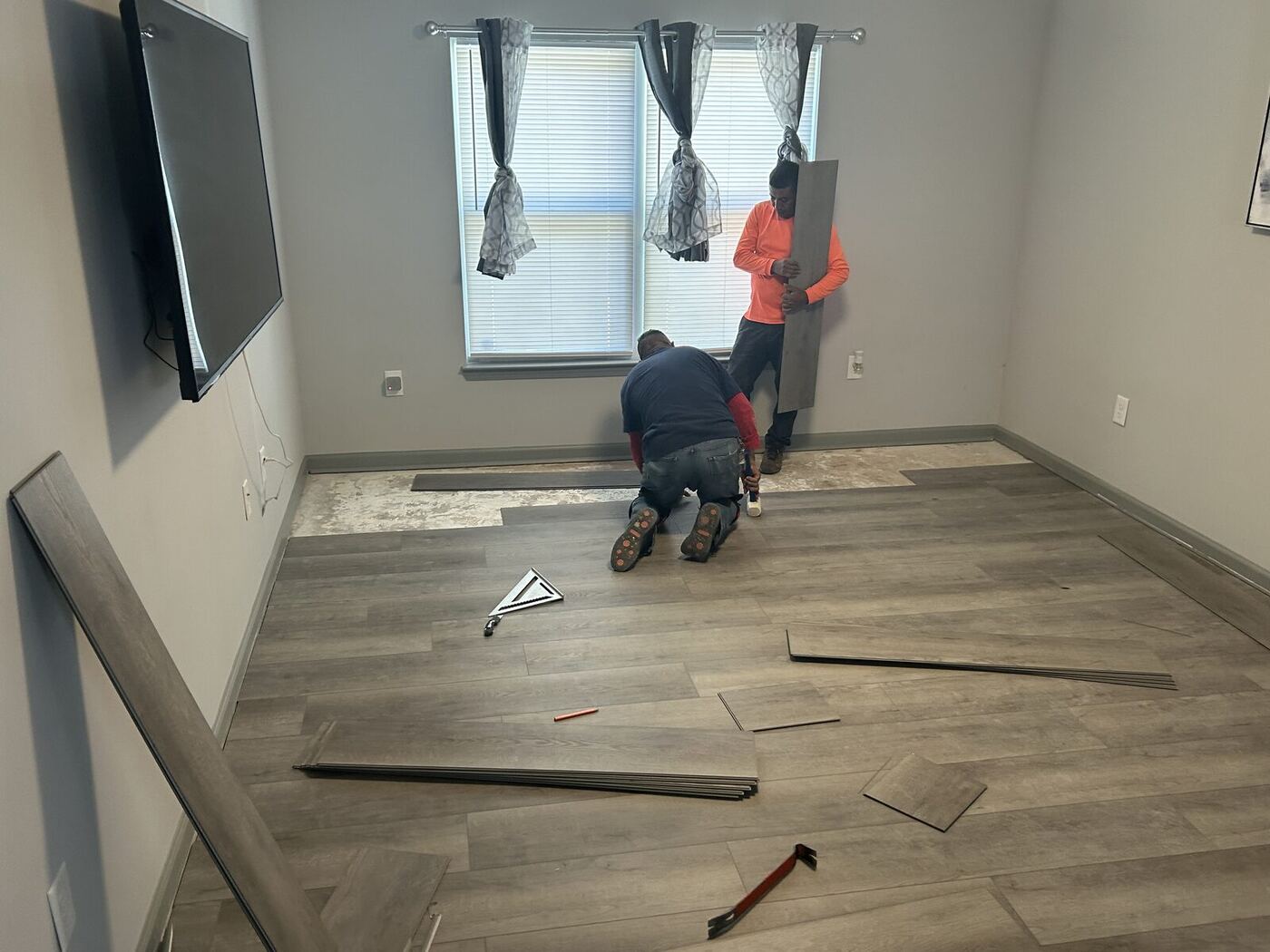 Crew measuring and cutting planks during a water damage rebuild