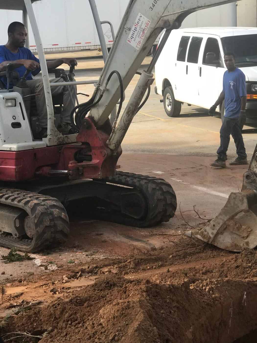 Excavator and service van on a commercial plumbing excavation job