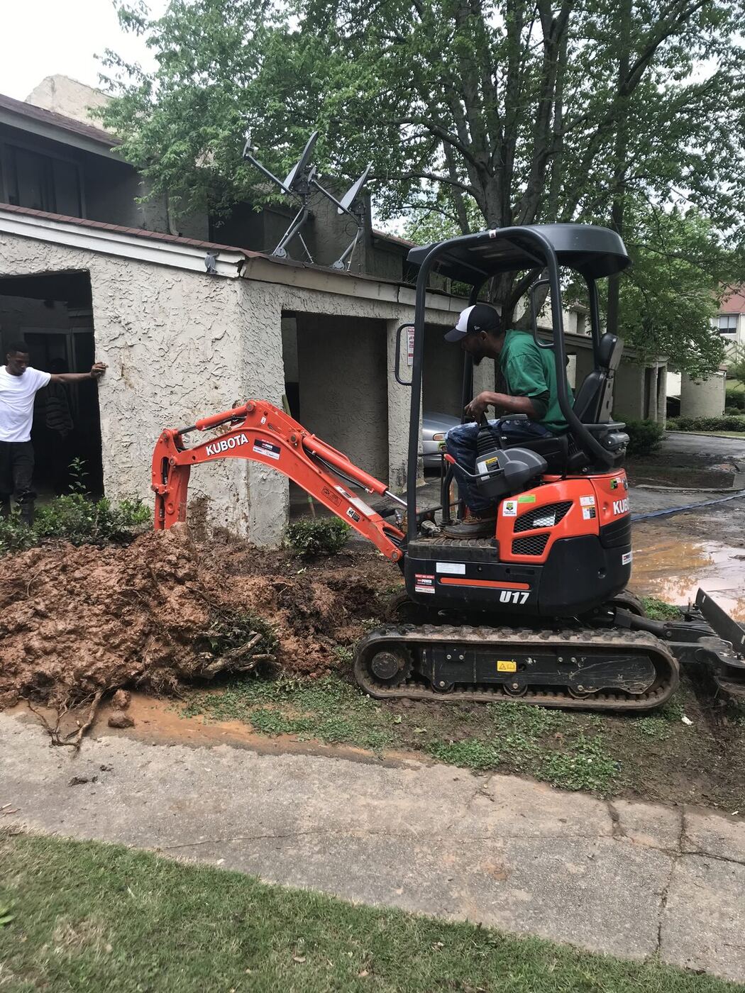 Kubota excavator staged in front of an Atlanta home for a sewer dig